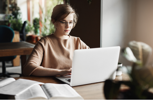 work-lifestyle-business-concept-good-looking-focused-european-female-trendy-glasses-sitting-cafe-near-laptop-working-notebook-surrounded-with-books-making-notes